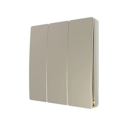 A gold three gang wall-mounted light switch