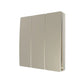 A gold three gang wall-mounted light switch