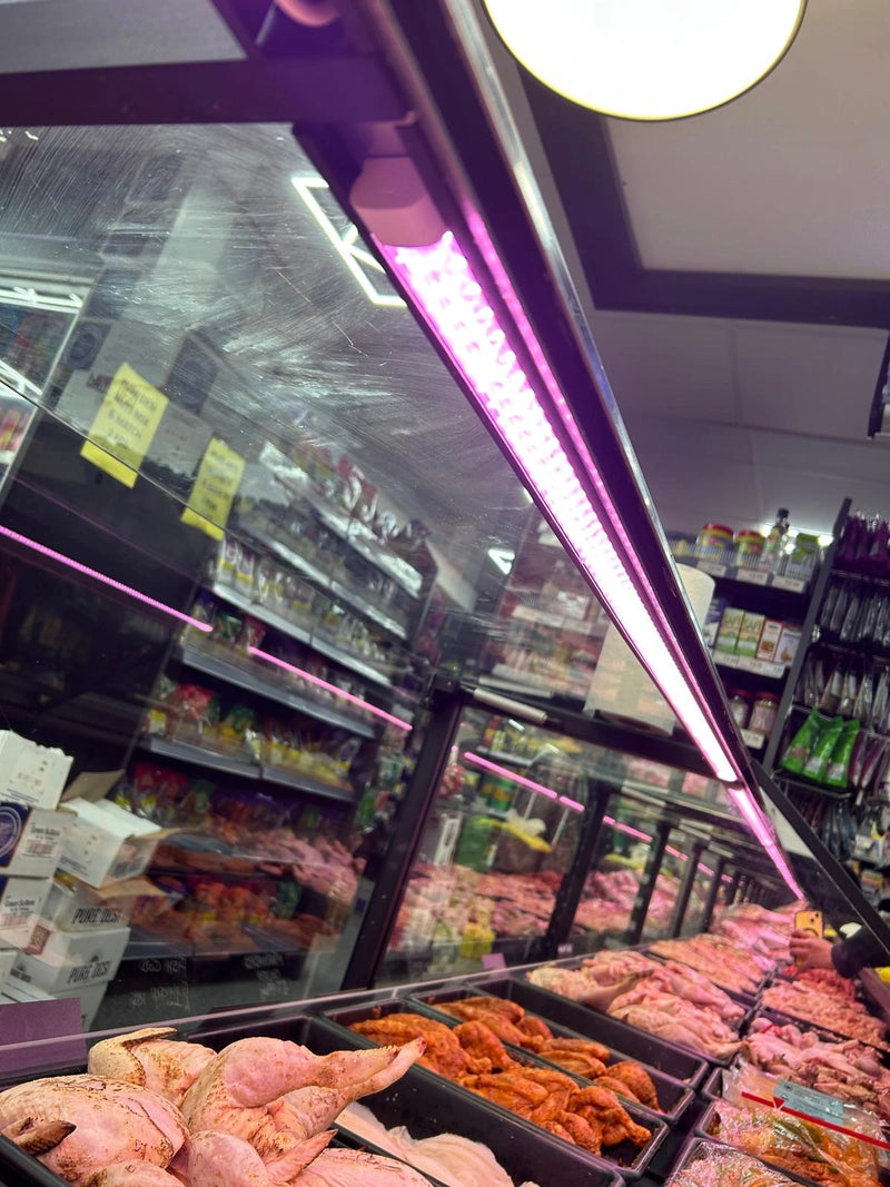 Meat display case in a grocery store with various cuts of meat.