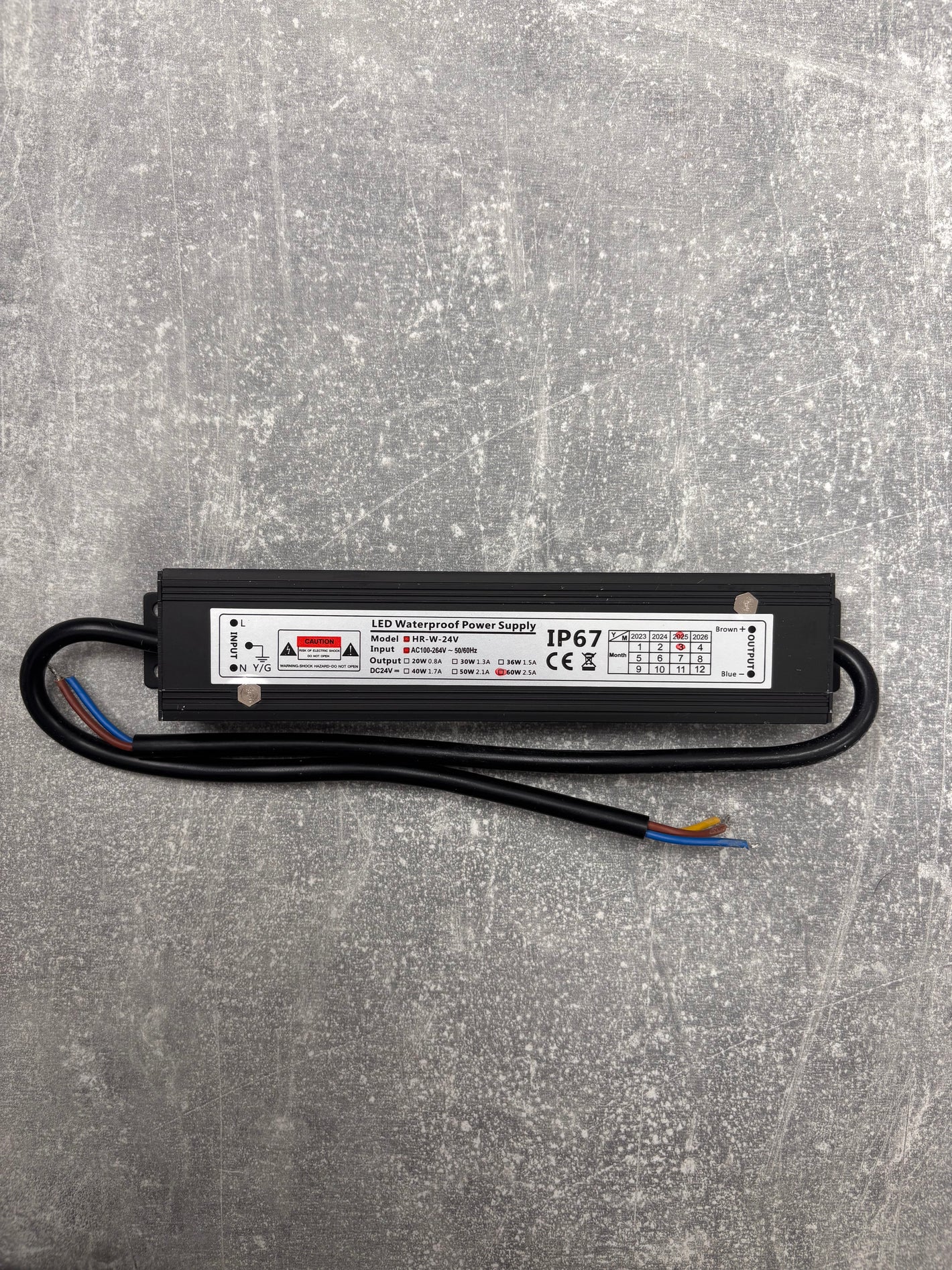 LED waterproof power supply driver on a gray textured surface