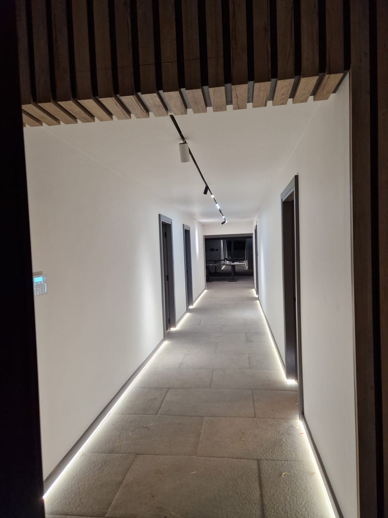 Long hallway with recessed lighting and a dark wooden ceiling.