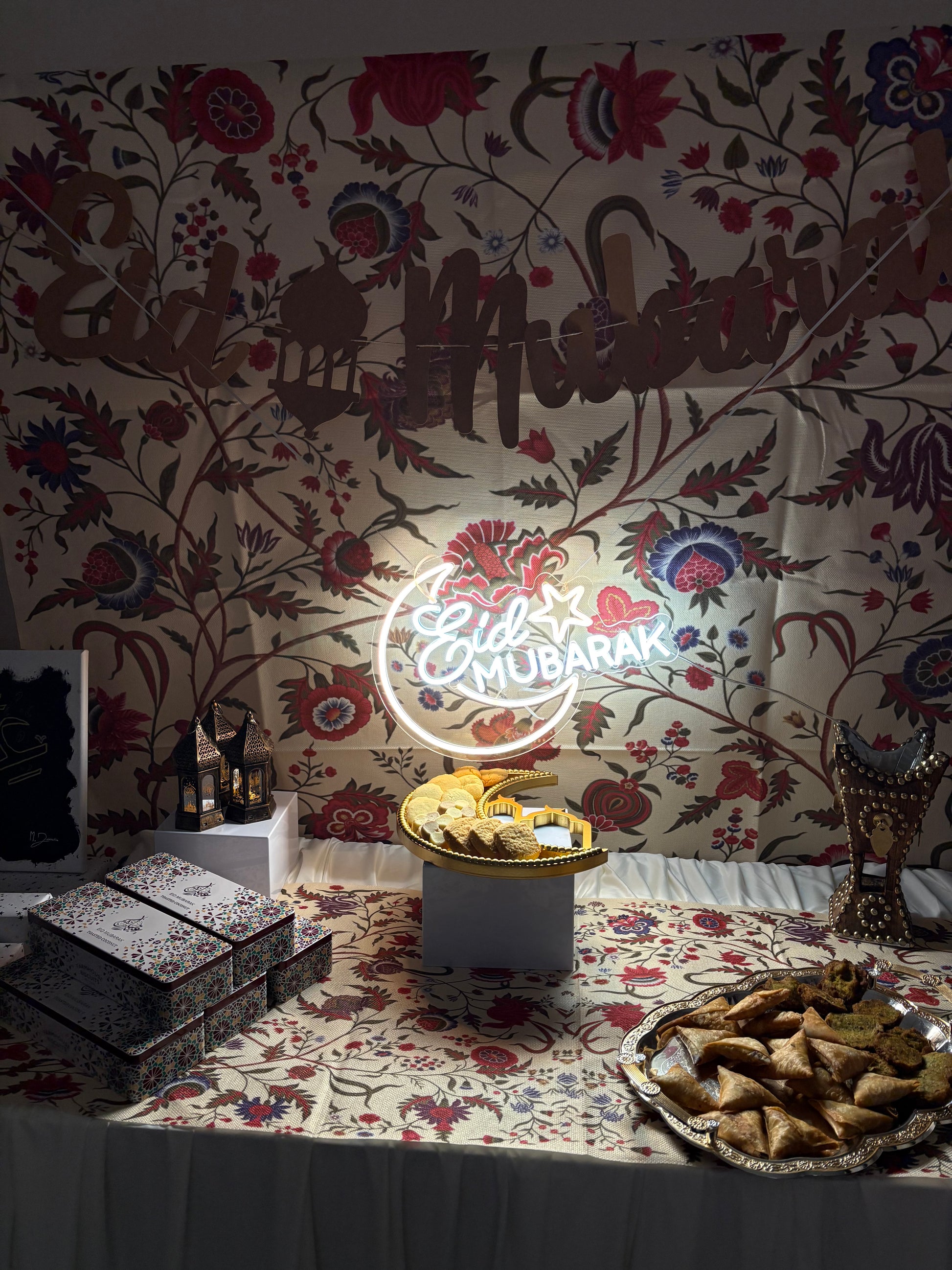 Eid Mubarak Neon sign on a decorative wall with floral and animal patterns