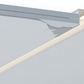 Close-up of a metal profile with a reflective surface on a light gray background