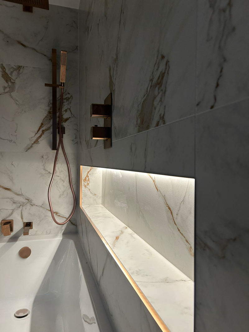 Modern bathroom with marble walls and a shower area.