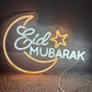 Neon sign with 'Eid Mubarak' text on a clear background