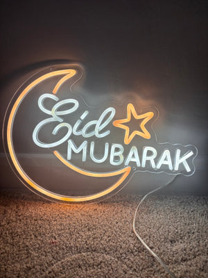 Neon sign with 'Eid Mubarak' text on a clear background