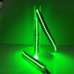 Green LED strip lights on a reflective surface with a green glow in the background