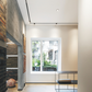 Modern interior space with magnetic track spotlights, featuring a bright window and a contemporary aesthetic with wood panel accents and a clean white ceiling.