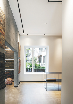 Modern interior space with magnetic track spotlights, featuring a bright window and a contemporary aesthetic with wood panel accents and a clean white ceiling.