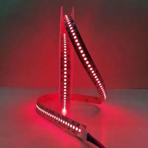 Red LED strip light on a white surface with a red background