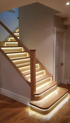 Wooden staircase with embedded lighting in a home interior.