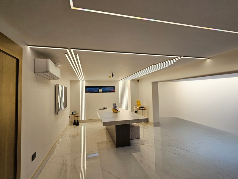 Modern office interior with a long desk, chairs, and decorative elements.